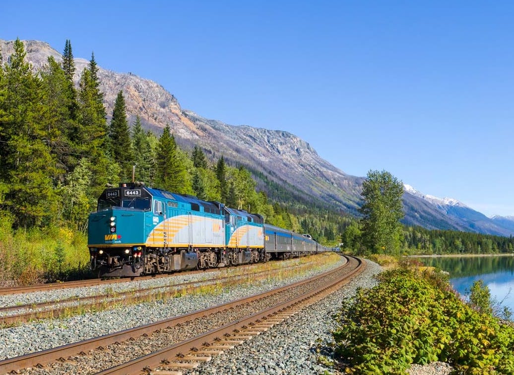 The Canadian train traveling through mountain scenery